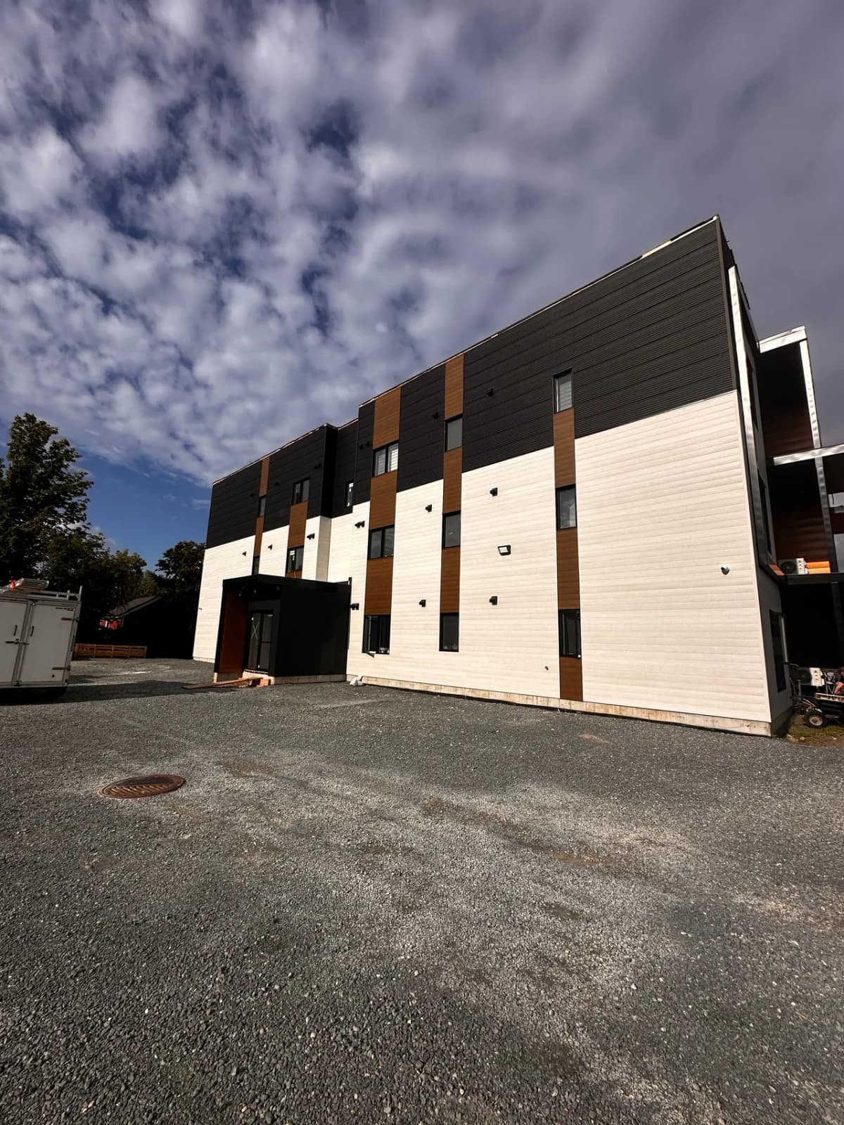 Side facade completed, black steel at the top with wood-tone bands