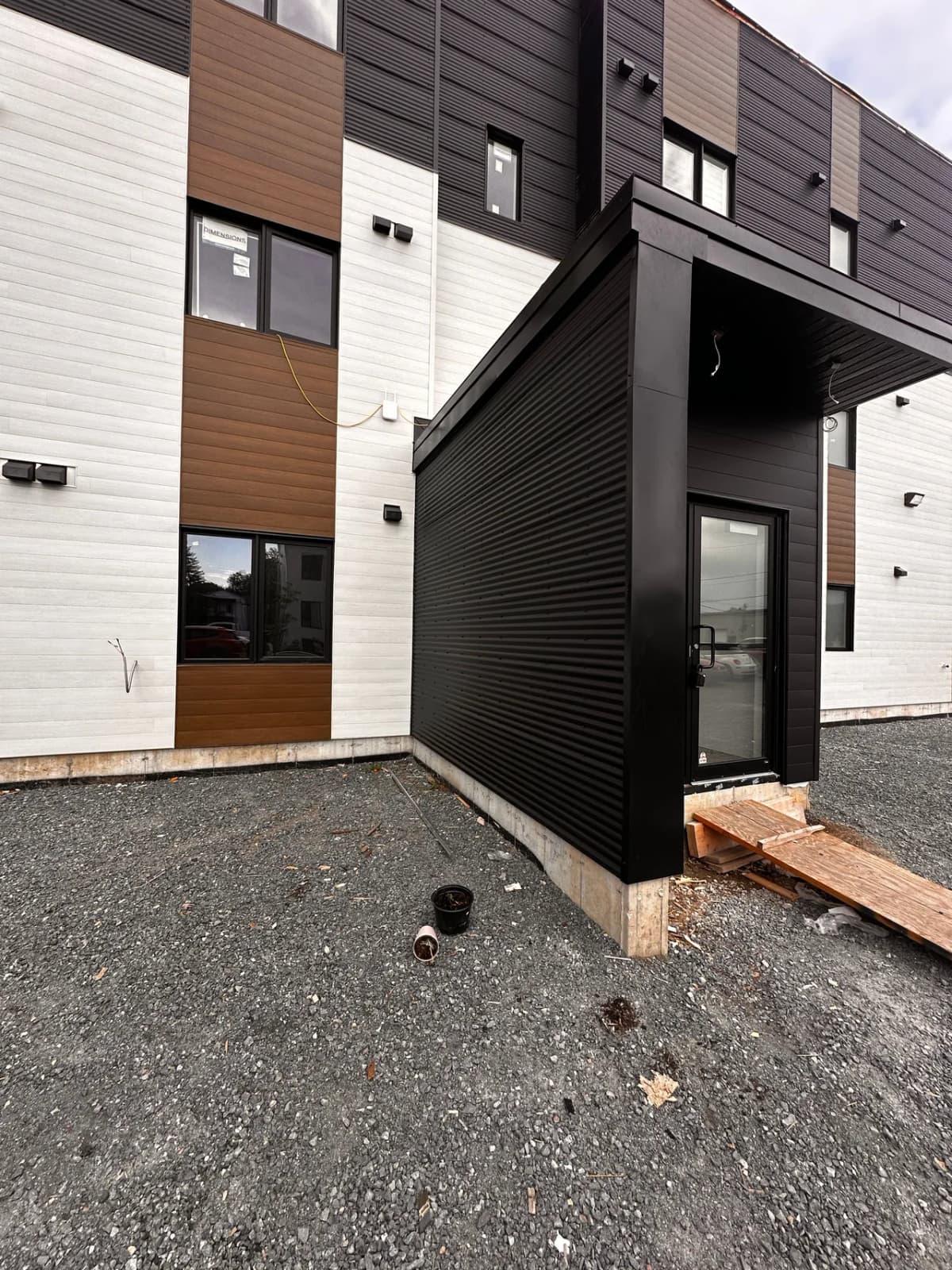 Black steel entry vestibule between the white and wood-tone sections