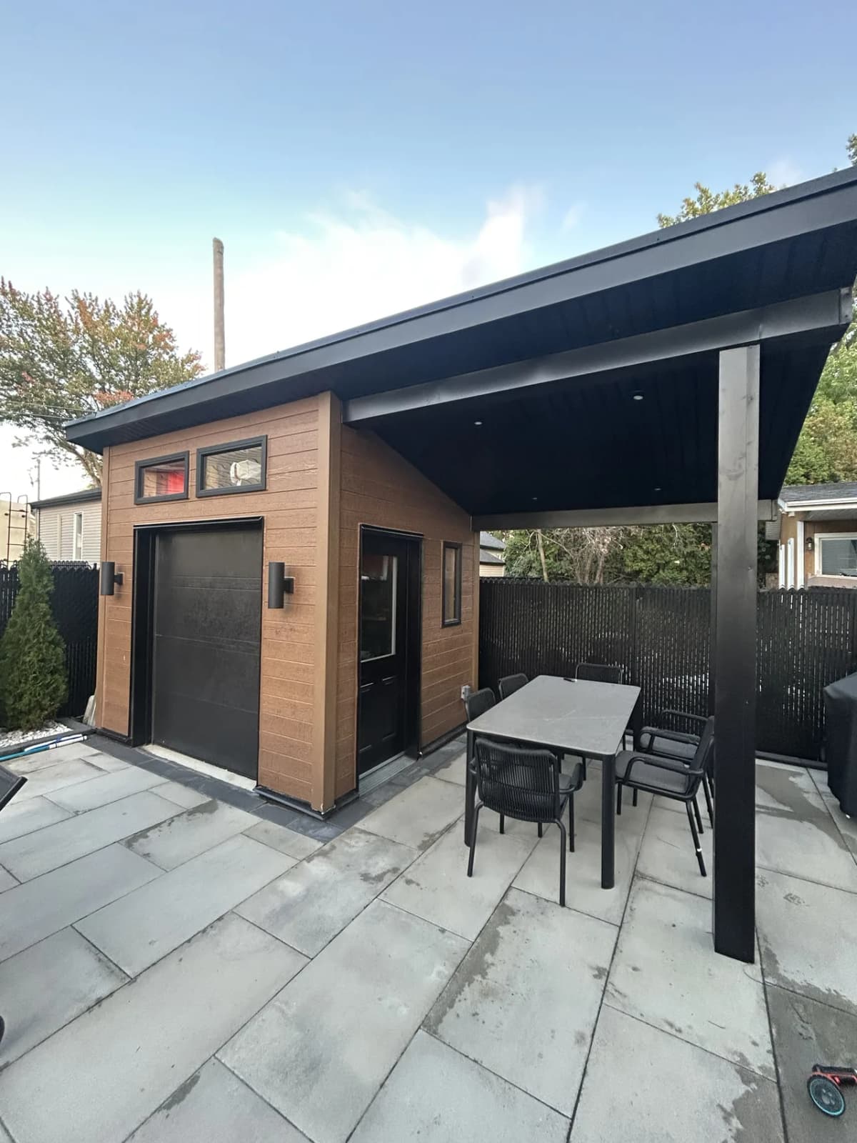 Cabanon terminé, porte de garage et fenêtres encadrées de noir