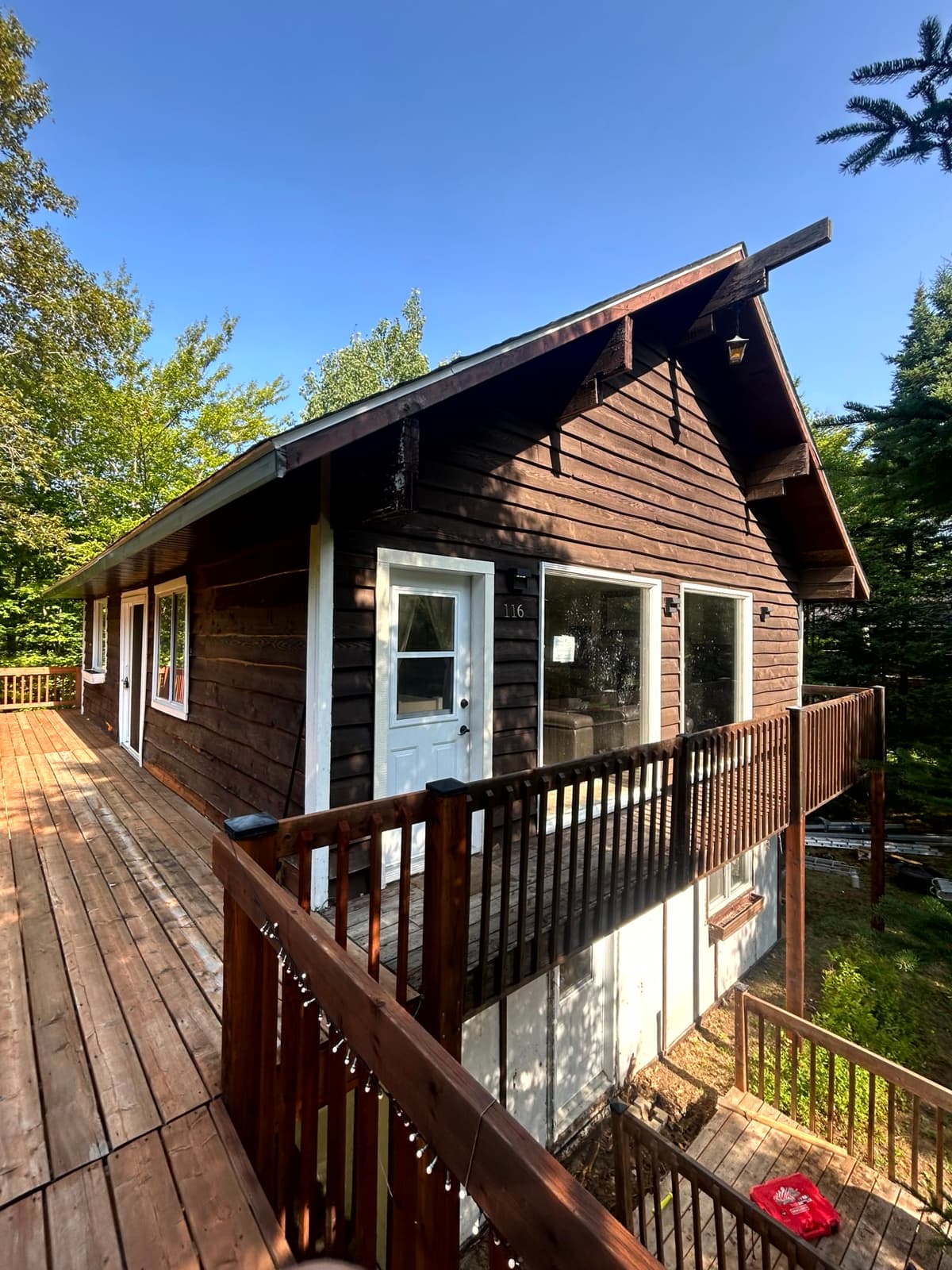 Avant : vieille façade en bois vieilli, deux niveaux de terrasses