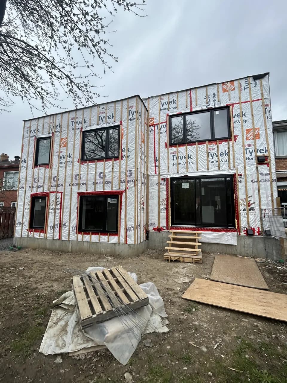 Solins rouges posés autour des fenêtres sur la membrane d'un bâtiment en chantier
